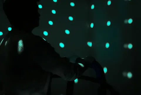 Une personne en train de faire des séances de stimulation optocinétique pour améliorer sa stabilité et son équilibre sous la supervision d'un professionnel de la réadaptation.